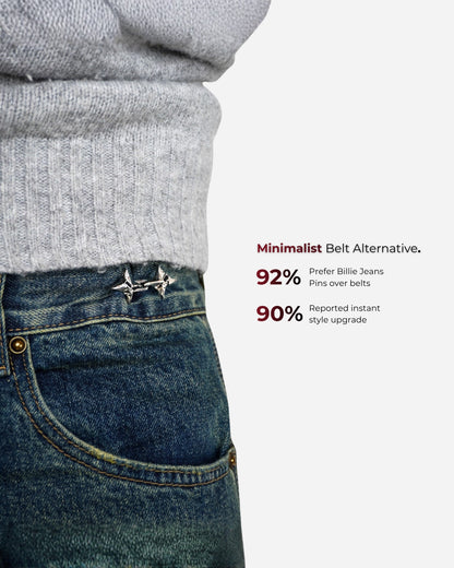 Close-up of a person wearing a gray sweater and blue jeans with decorative pins.