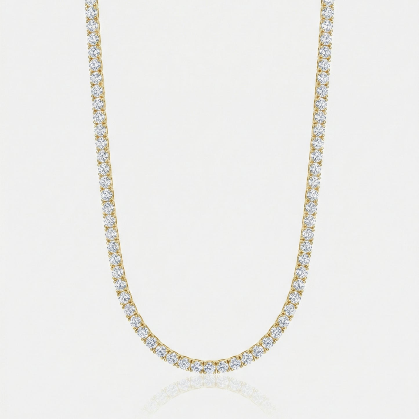 Gold necklace with clear stones on a light gray background
