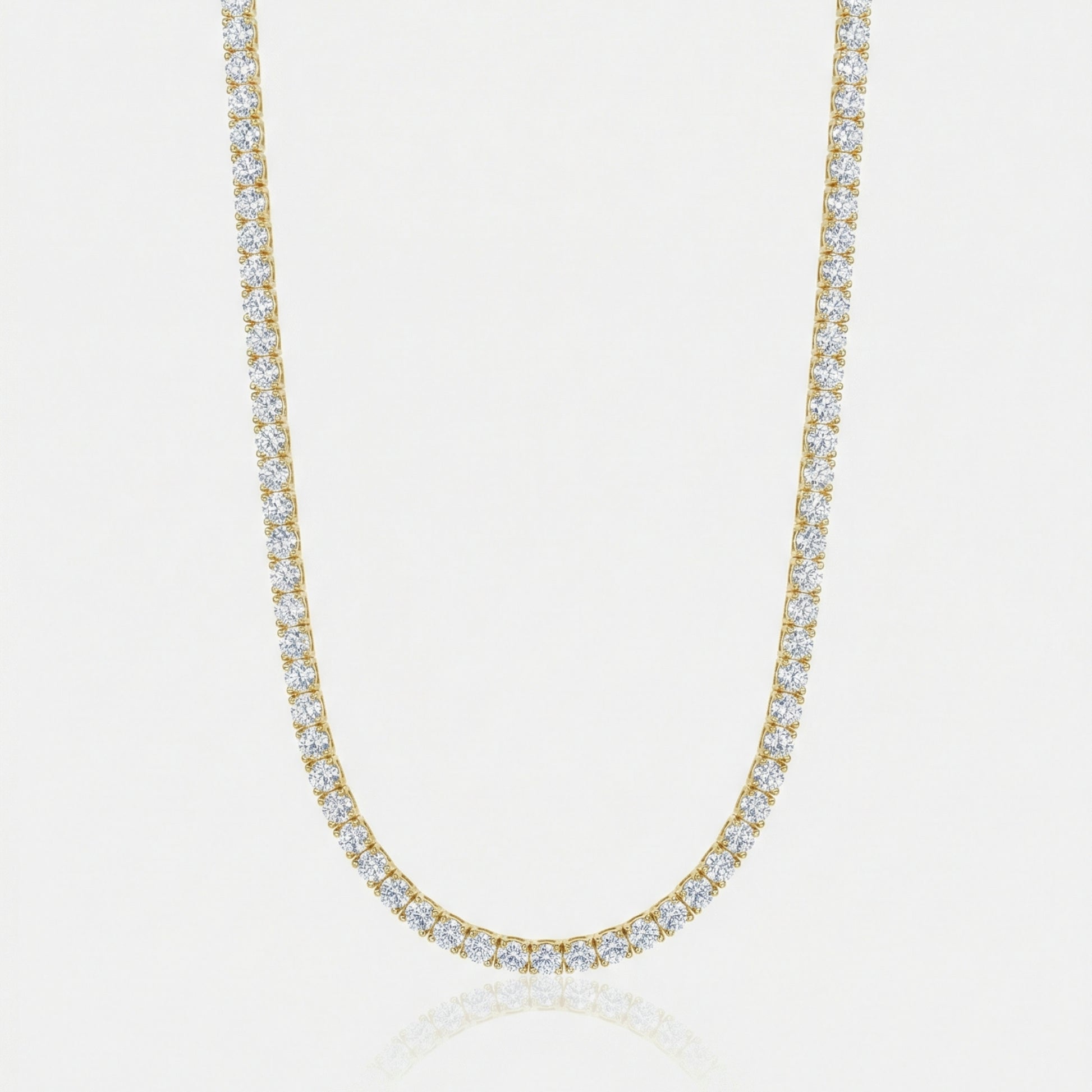Gold necklace with clear stones on a light gray background