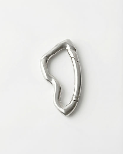 Wavy silver metal clip on a plain white background