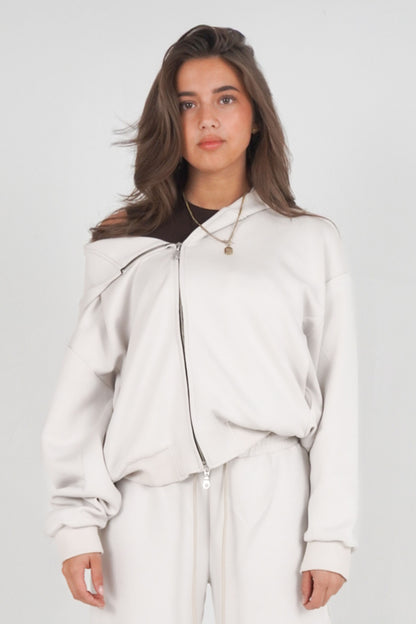 Woman wearing a light gray outfit against a plain background