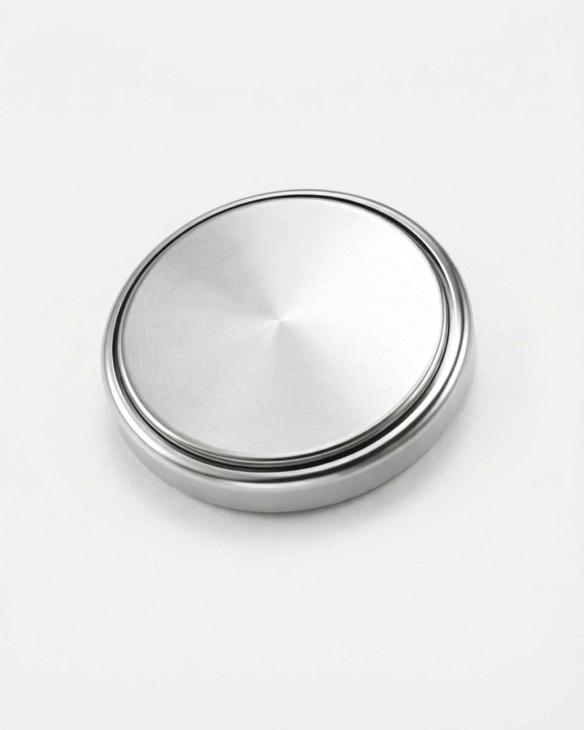Round metallic object with a brushed finish on a plain white background.