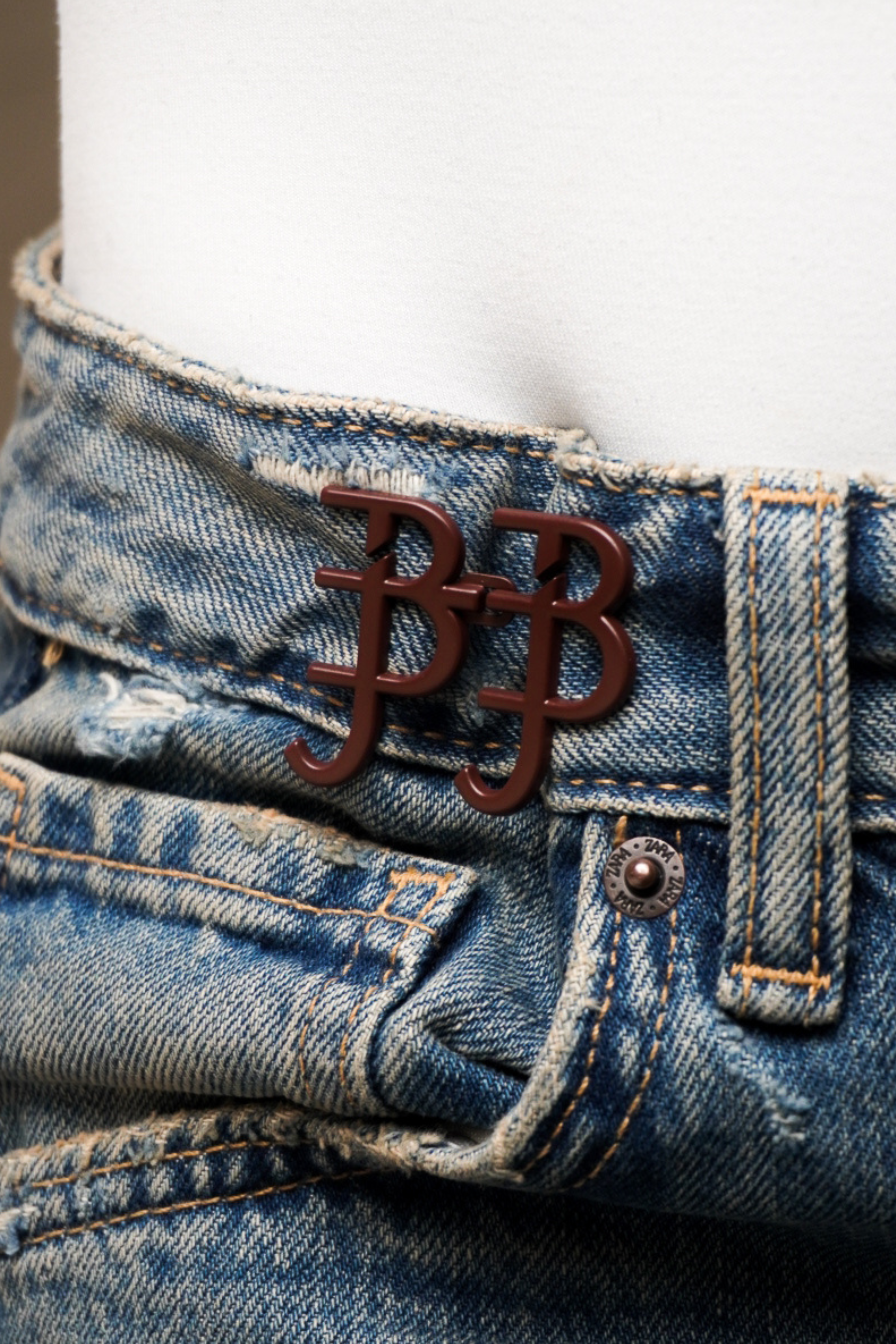 Close-up of blue jeans with red waist knots 