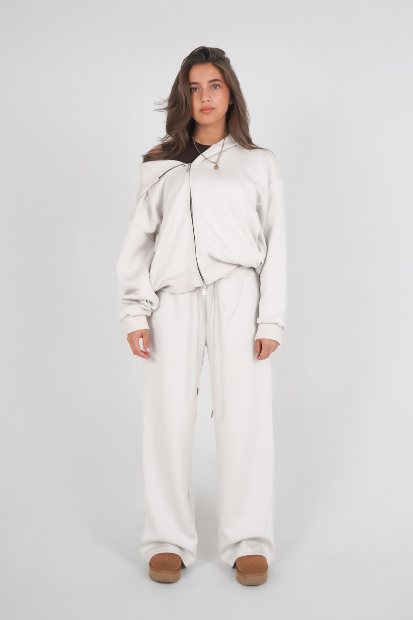 Person wearing a light gray outfit on a white background