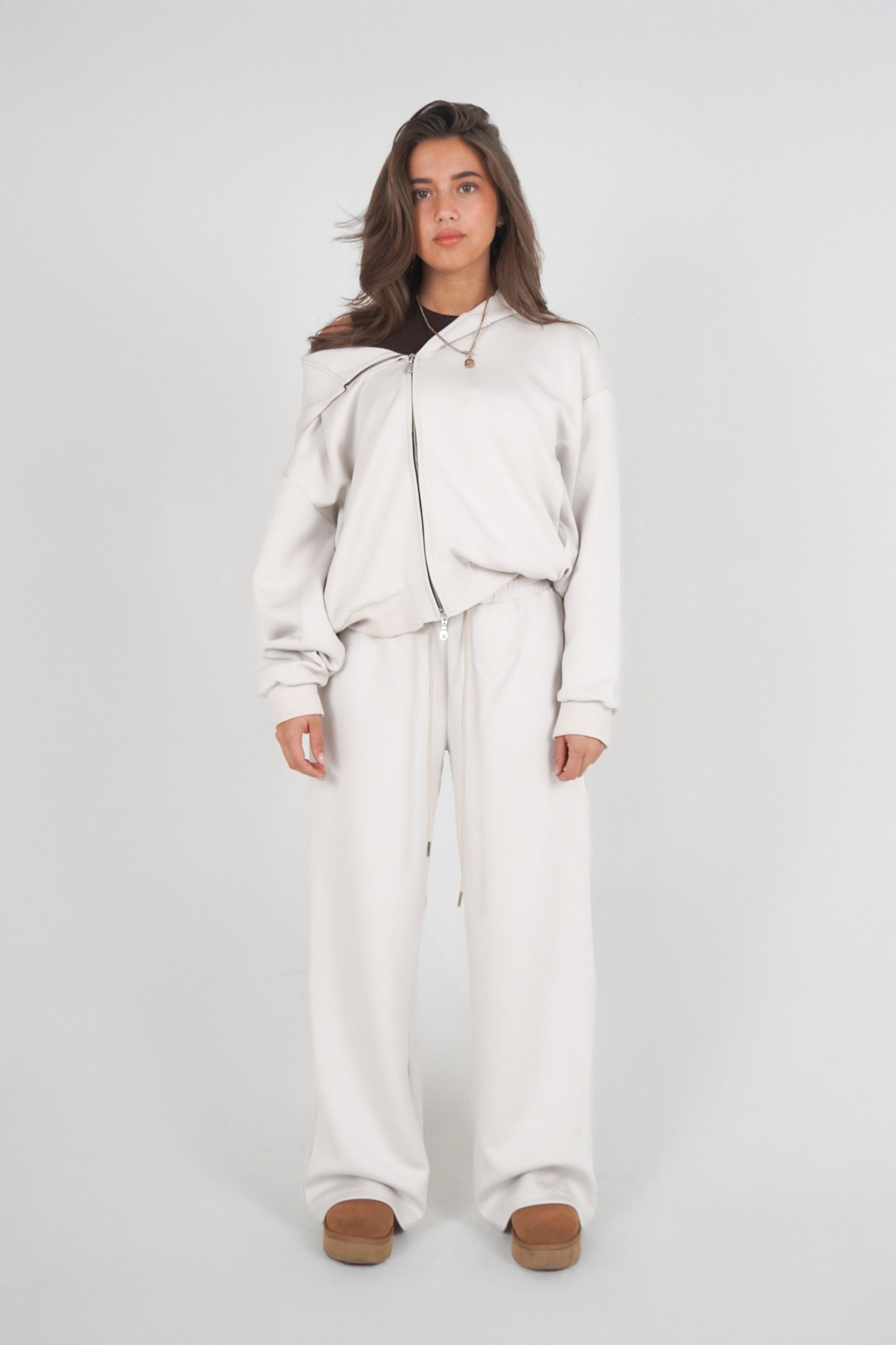 Person wearing a light gray outfit on a white background