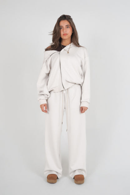 Person wearing a light gray outfit on a white background