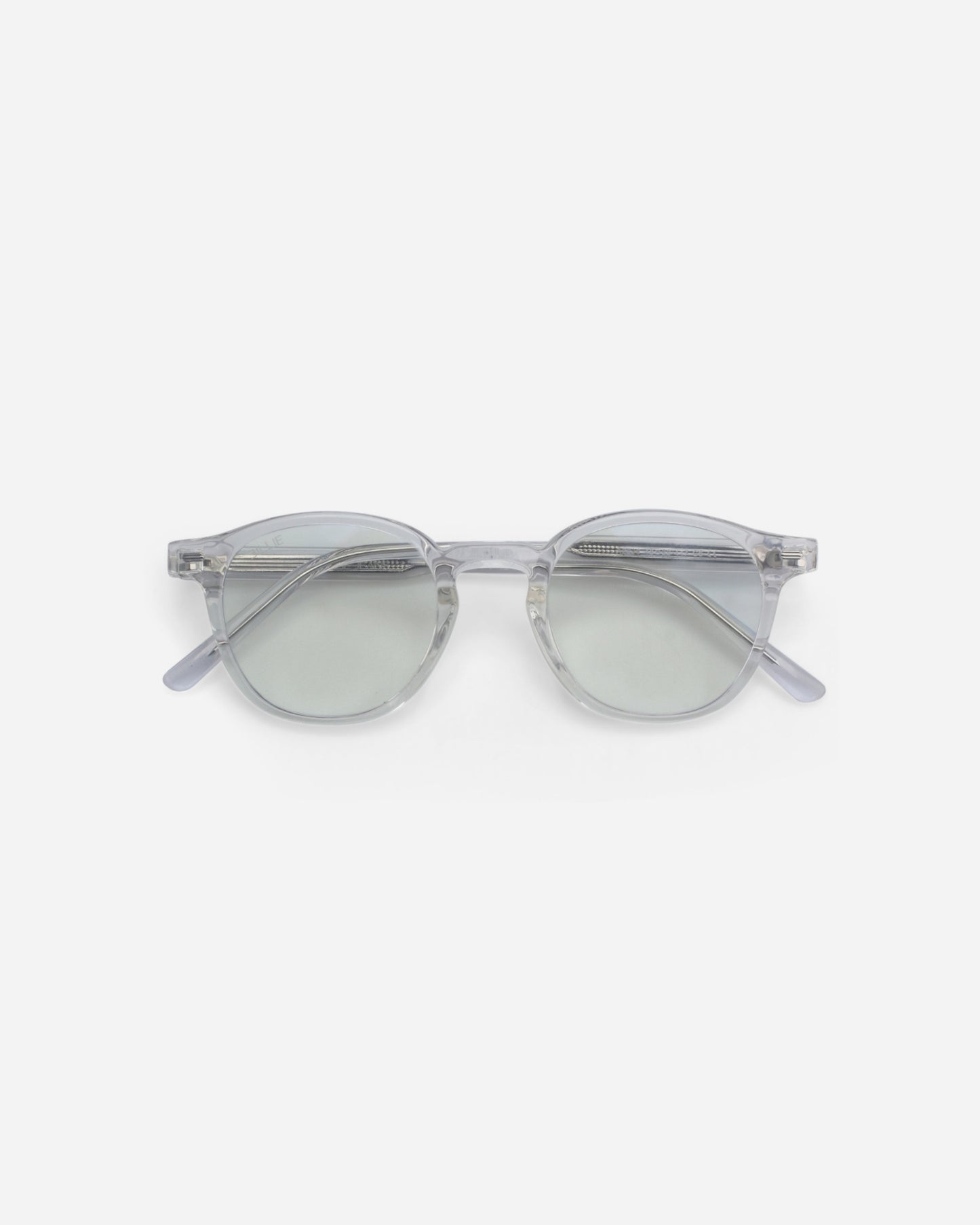 Clear framed sunglasses with light green lenses on a plain background