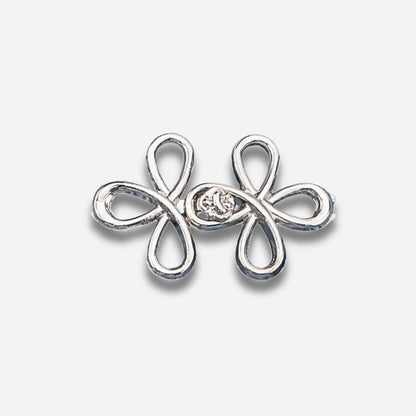 Zilveren vlindervormige oorbel met een centrale edelsteen op een lichtgrijze achtergrond