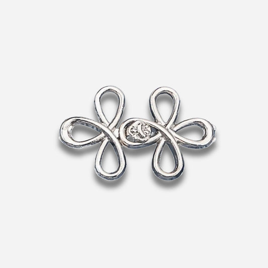 Zilveren vlindervormige oorbel met een centrale edelsteen op een lichtgrijze achtergrond