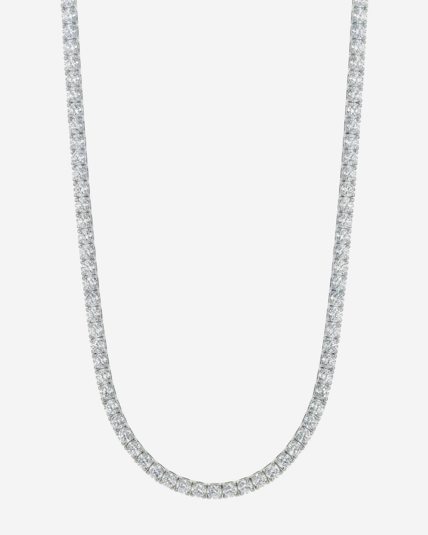 Silver necklace with a row of clear stones on a plain background.