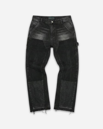 Black jeans with varying shades and distressed hem, displayed on a plain background.