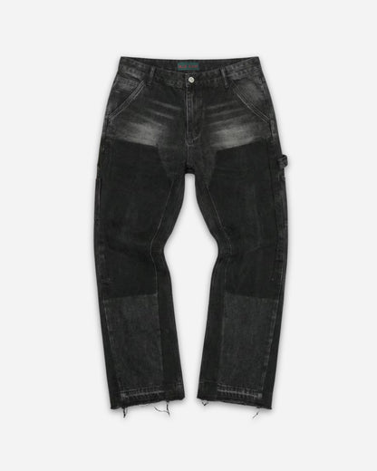 Black jeans with varying shades and distressed hem, displayed on a plain background.