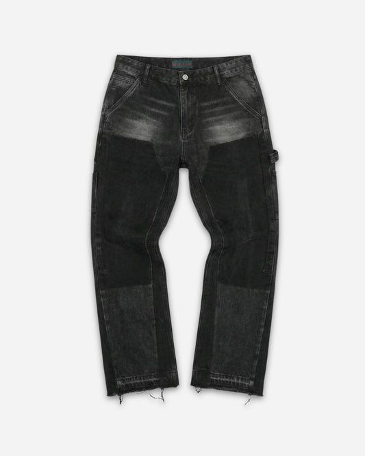 Black jeans with varying shades and distressed hem, displayed on a plain background.