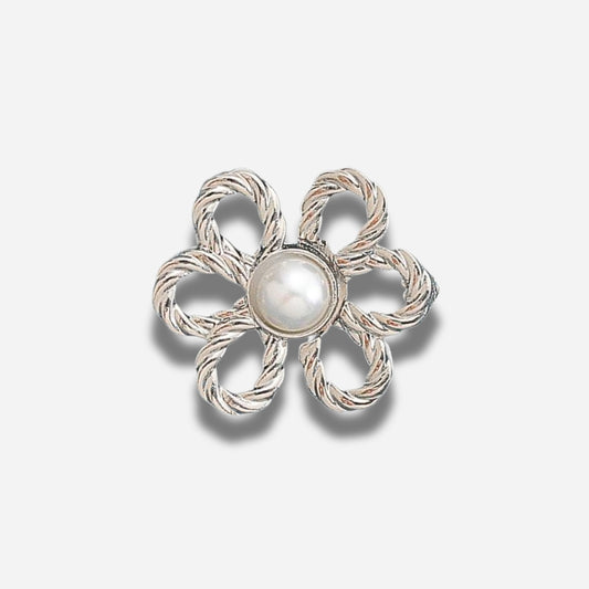 Zilveren bloemvormige broche met een centrale parel op een lichtgrijze achtergrond