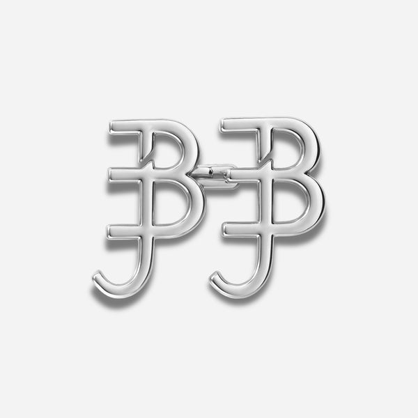 Zilveren broche met een monogramontwerp op een witte achtergrond