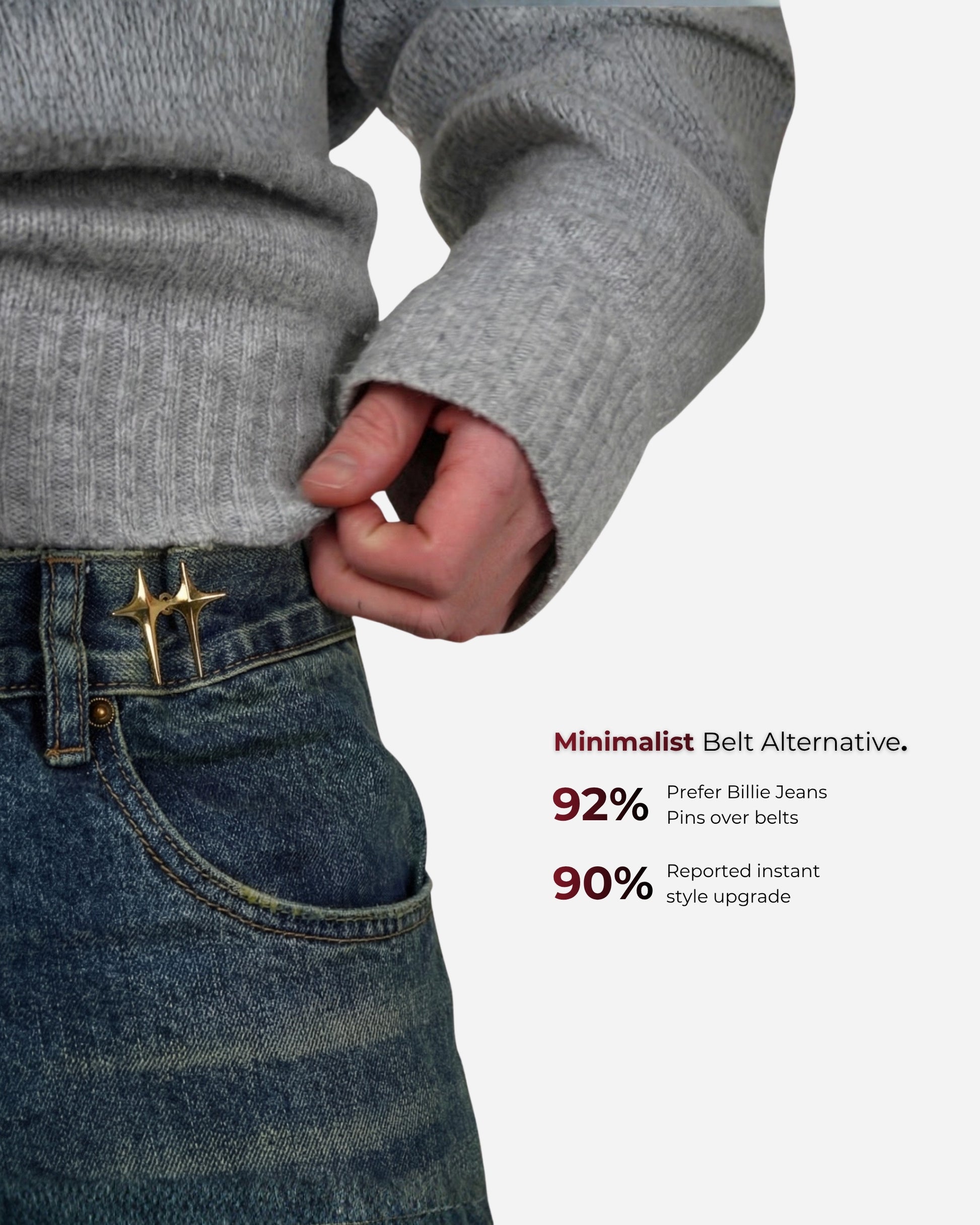 Person wearing a gray sweater and holding a gold pin on denim jeans.