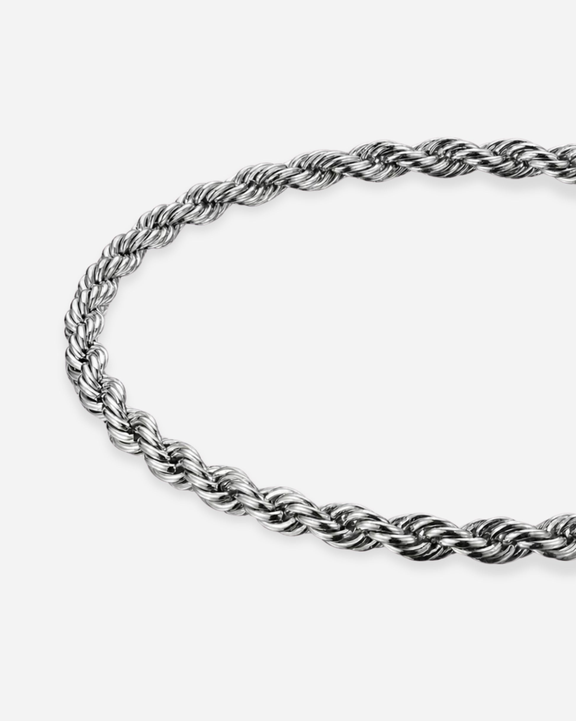 Twisted silver chain necklace on a plain background