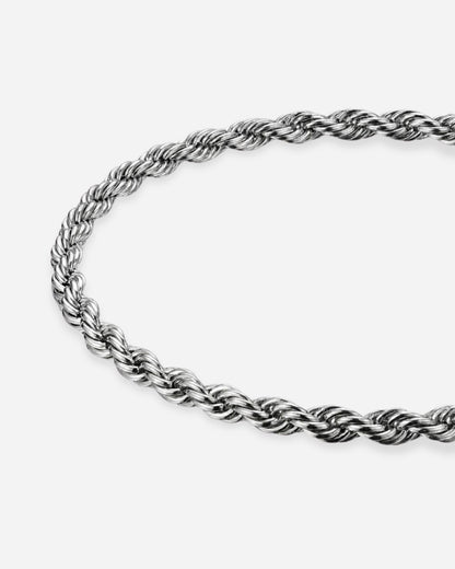 Twisted silver chain necklace on a plain background
