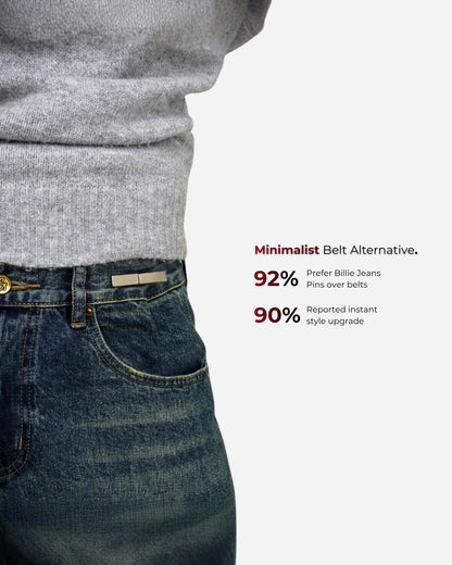 Close-up of a person wearing a gray sweater and jeans with a silver pin at the waist.