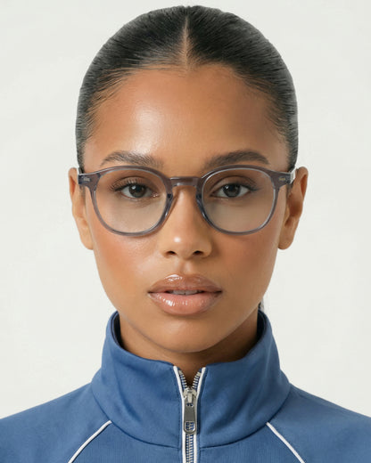 Close-up of a person wearing glasses and a blue zip-up jacket.
