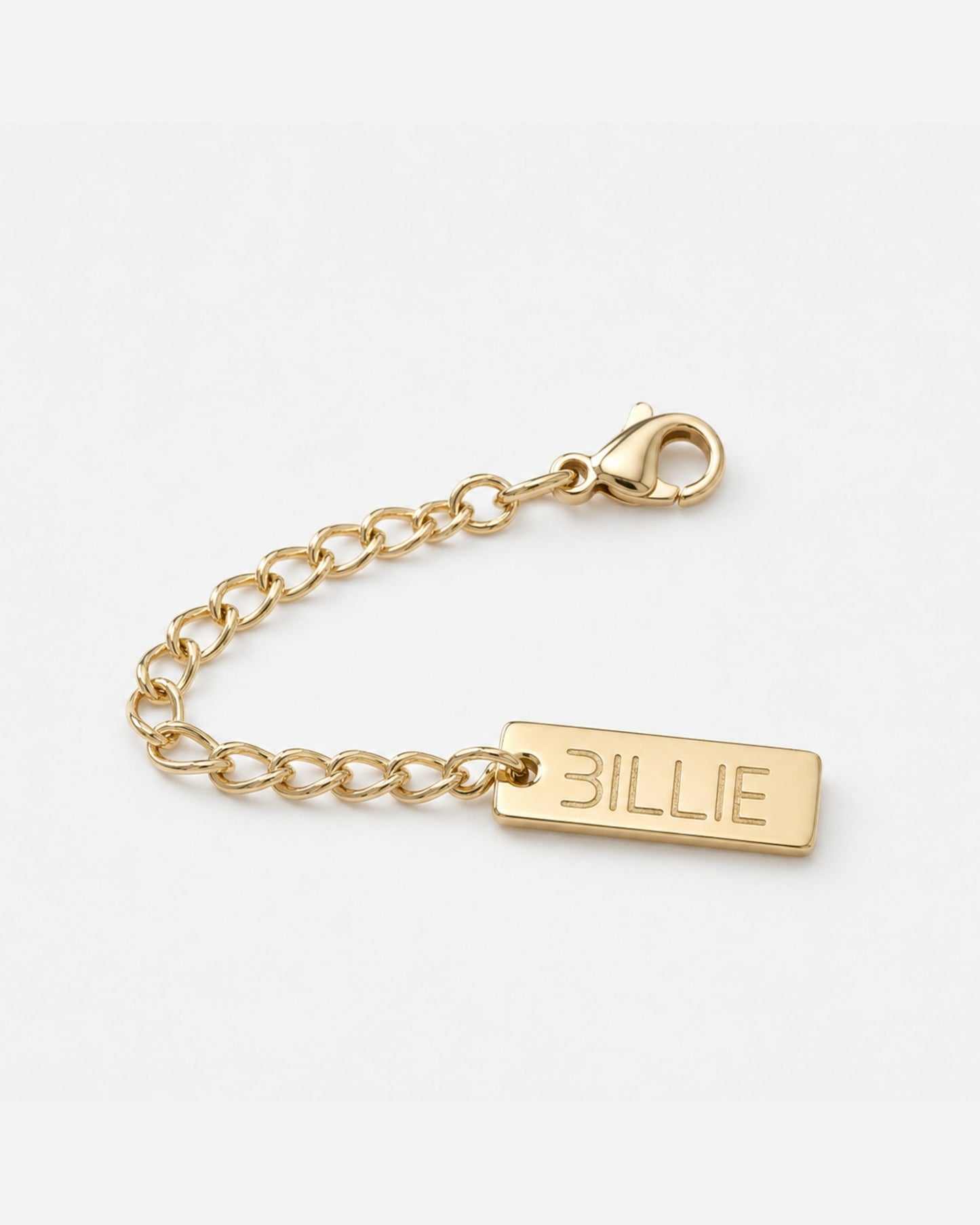 Gold chain with a rectangular tag engraved with the word 'BILLIE'.