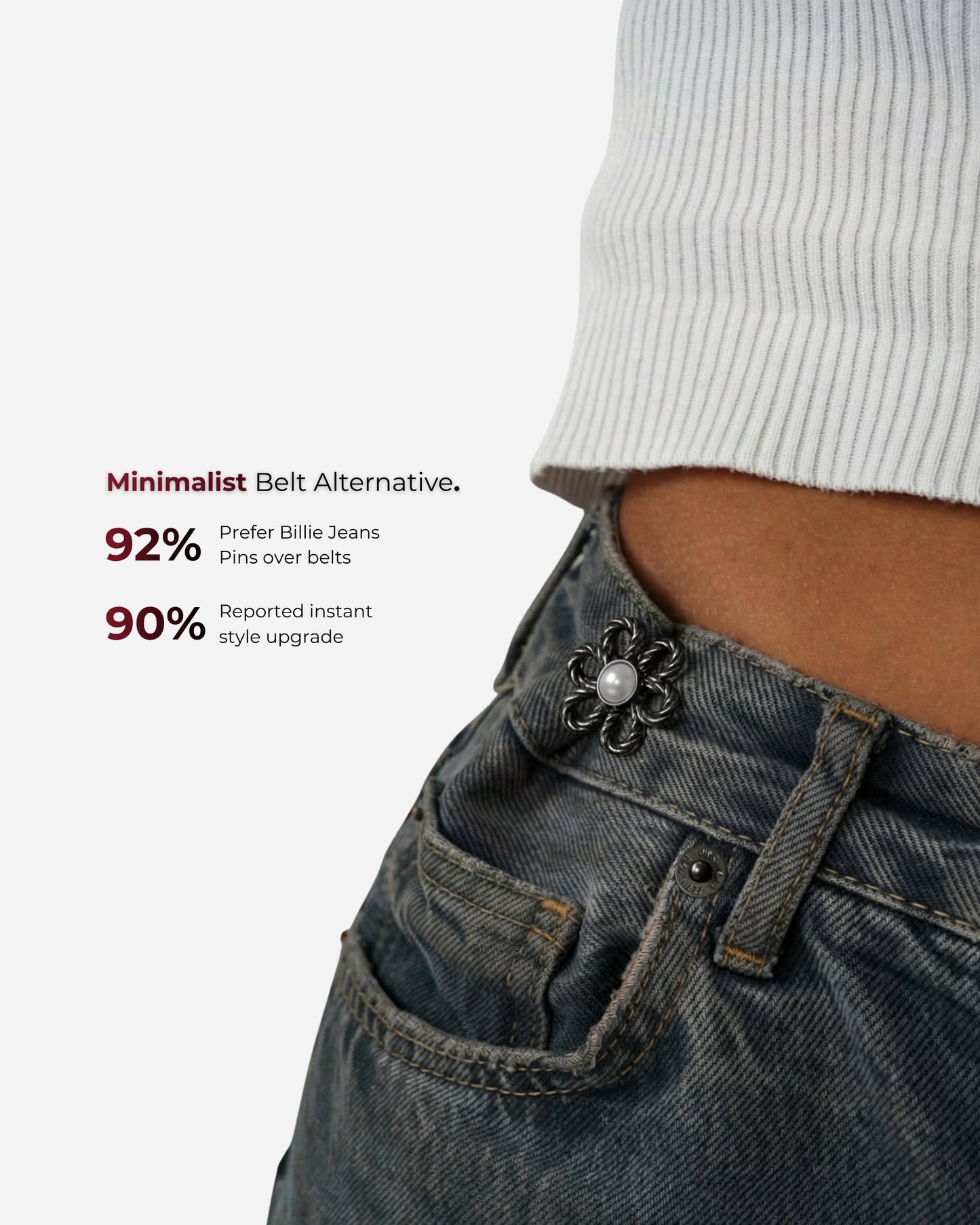 Close-up of a waist with a decorative pin on denim pants and a ribbed top.