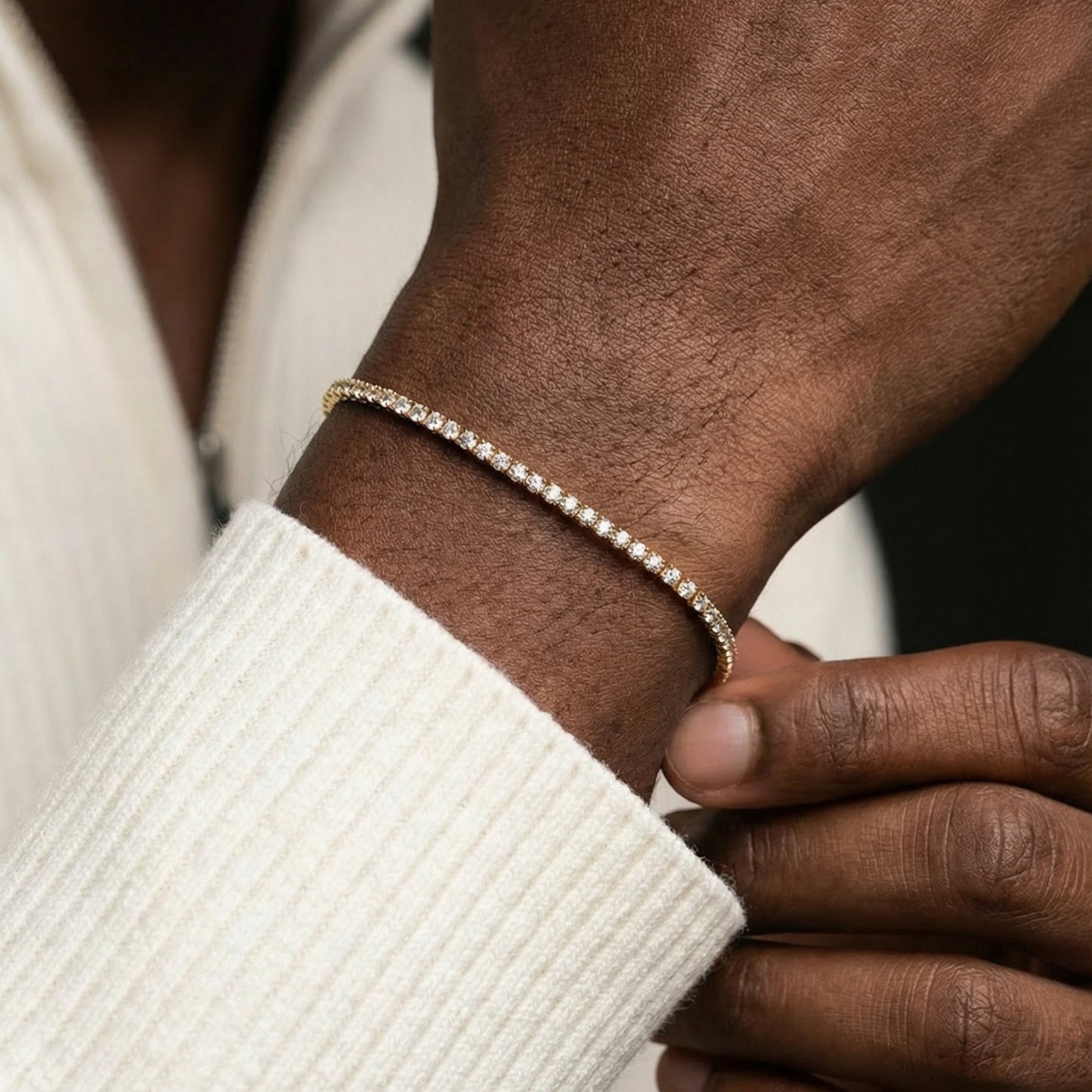 Close-up of a hand wearing a diamond bracelet with a blurred background