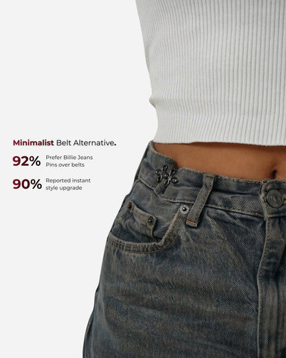 Close-up of a waist with a white ribbed top and dark jeans, featuring visible buttons and pockets.