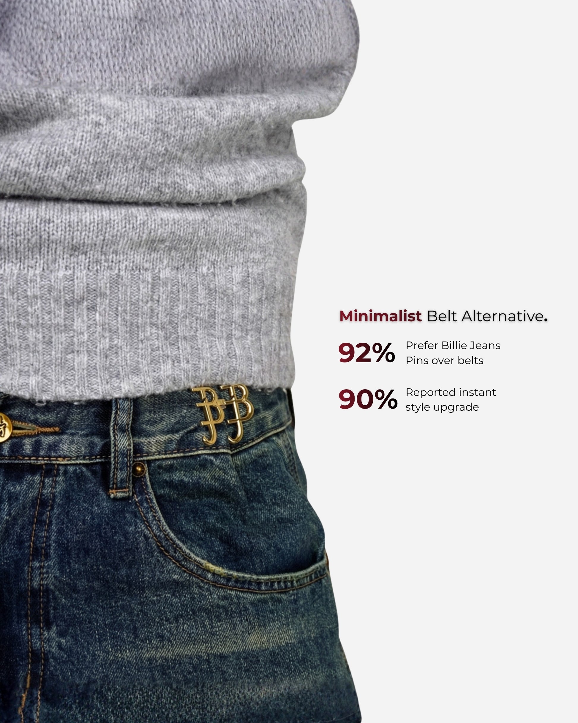 Close-up of a gray sweater and denim with a gold pin at the waist.