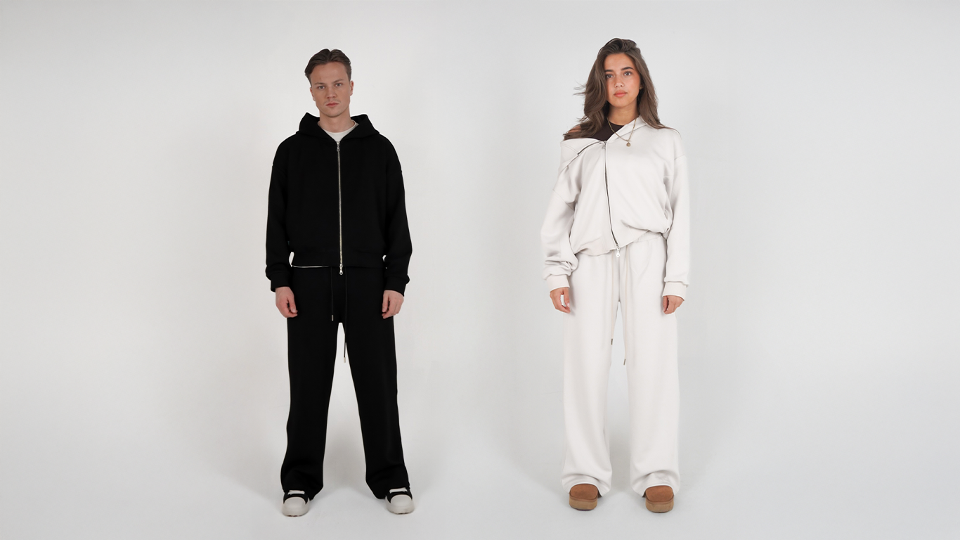 Two people wearing black and white outfits on a plain background