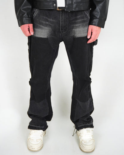 Person wearing black pants and white sneakers, standing against a plain background.