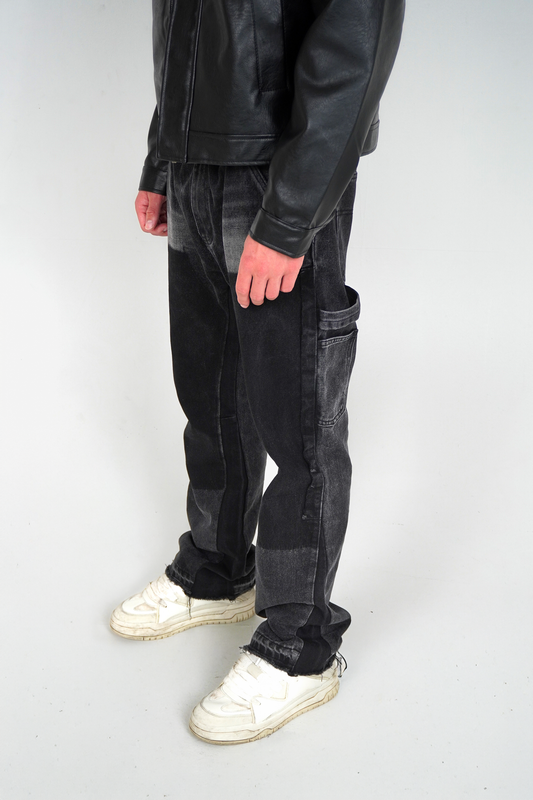 Person wearing black leather jacket and dark jeans on a white background