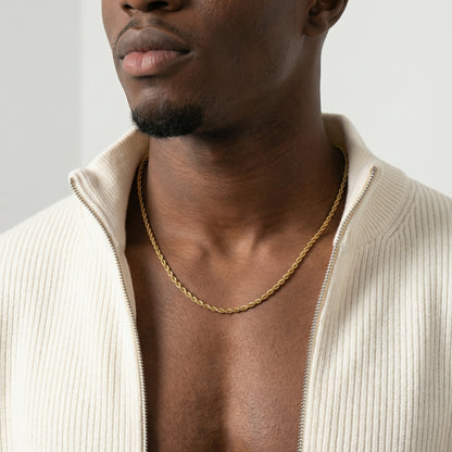 Man wearing a gold chain necklace with a plain background