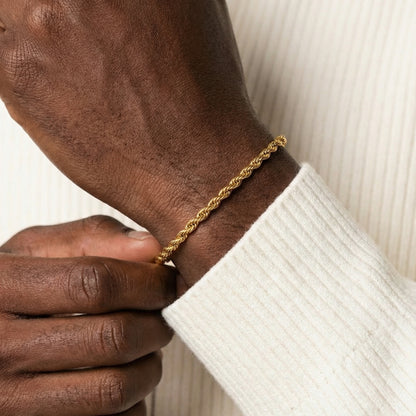 Gold bracelet on a wrist with a white sleeve