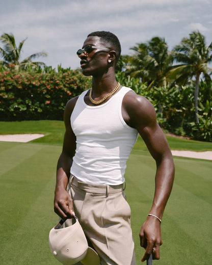 Man in a white tank top wearing the gold Billie Cuban Chain 12mm on a golf course