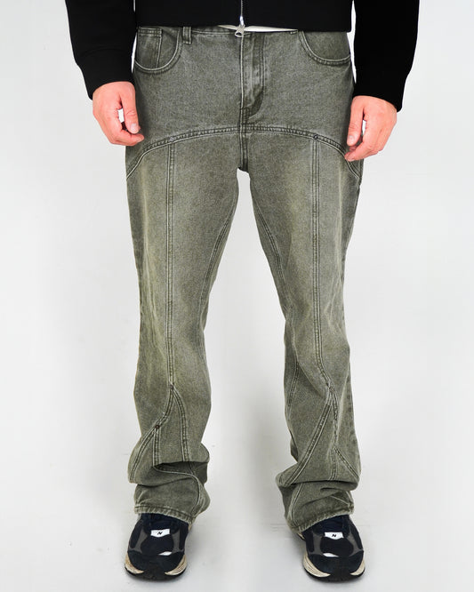 Person wearing green pants and black shoes, standing against a light background.