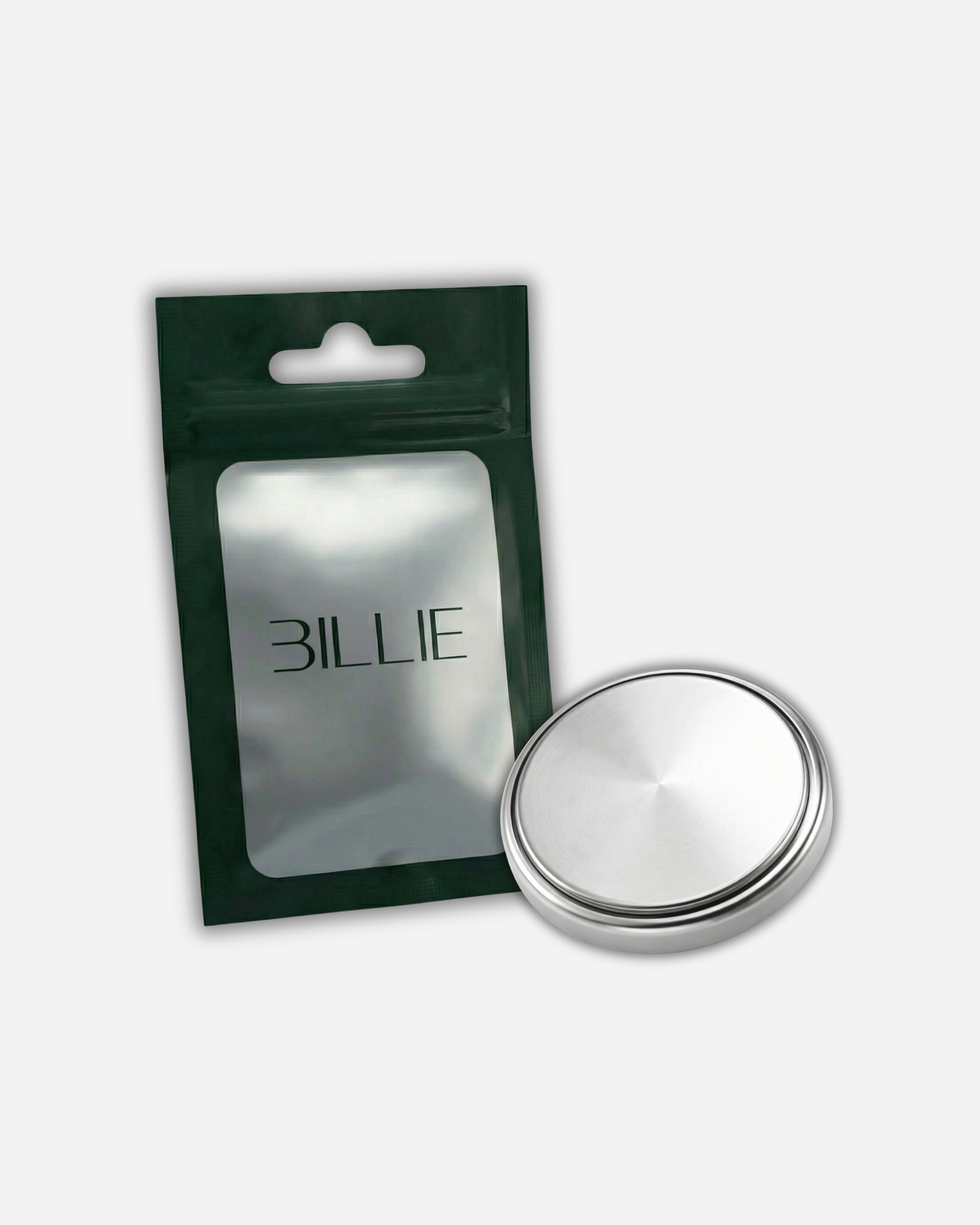 Silver circular object next to a green packaging with visible text.