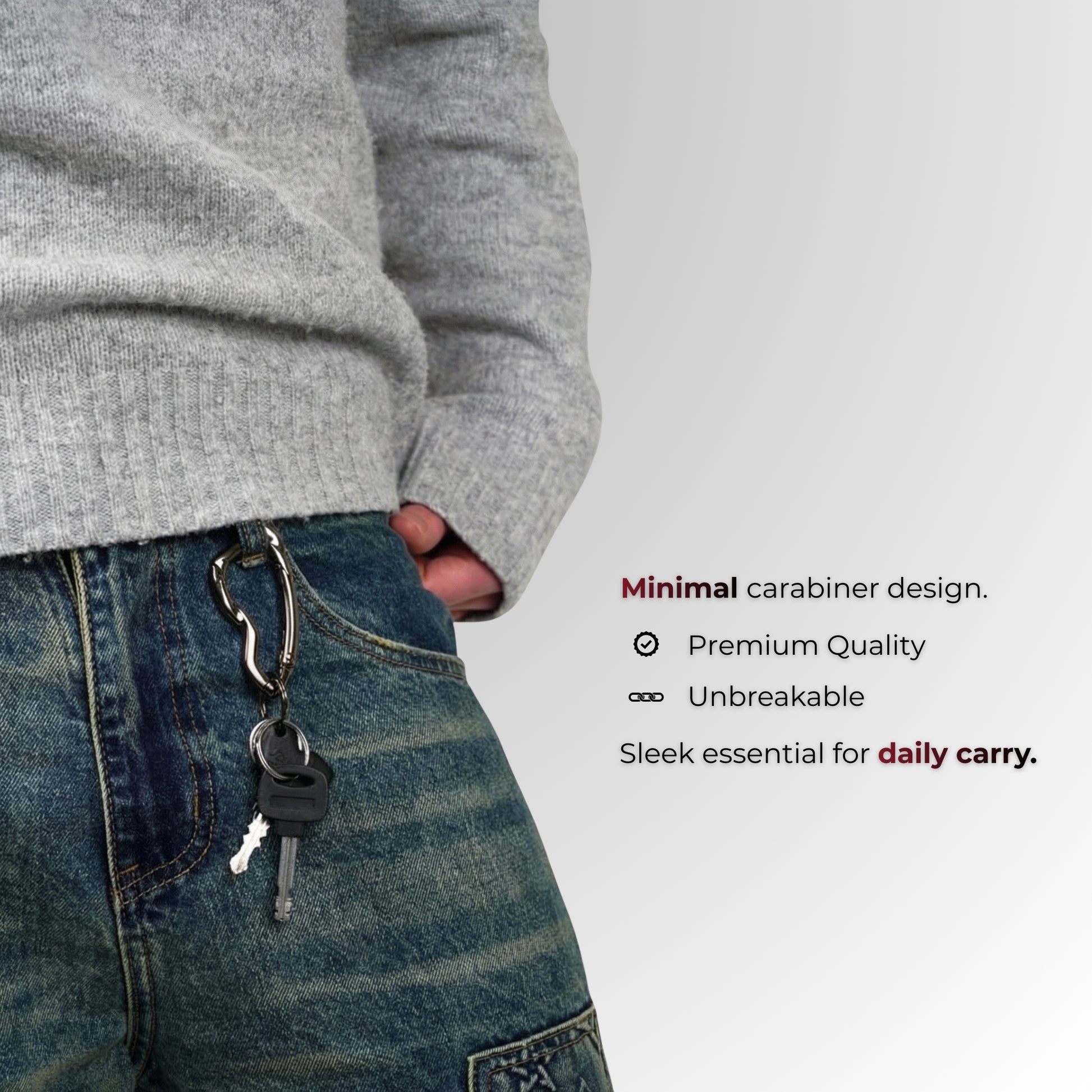 Person wearing a gray sweater and blue jeans with a keychain, on a light gray background.