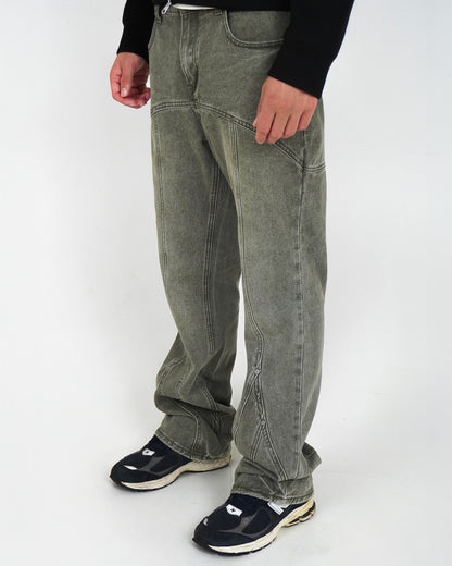 Person wearing light gray pants and black sneakers, standing on a plain background.