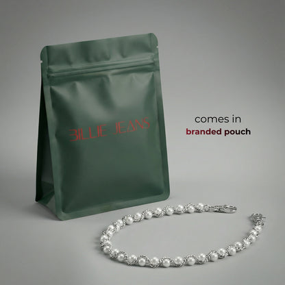 Grüner Markenbeutel mit einer Perlenkette auf grauem Hintergrund