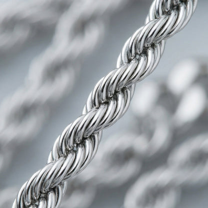 Close-up of a silver braided chain against a blurred metallic background