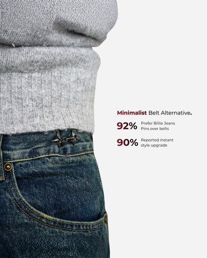 Close-up of a gray sweater and denim waistband with pins, text on the side.