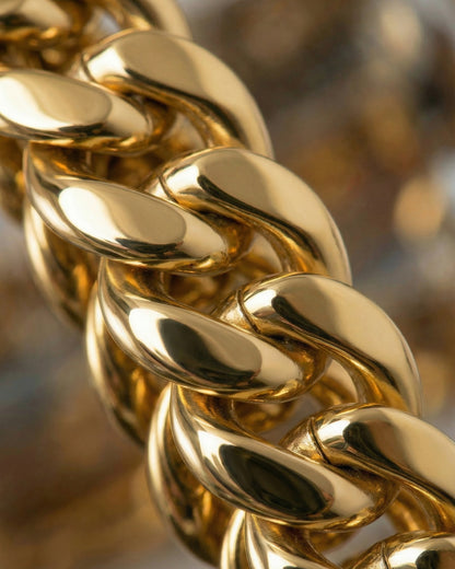 Close-up of a shiny gold chain with interlocking links.