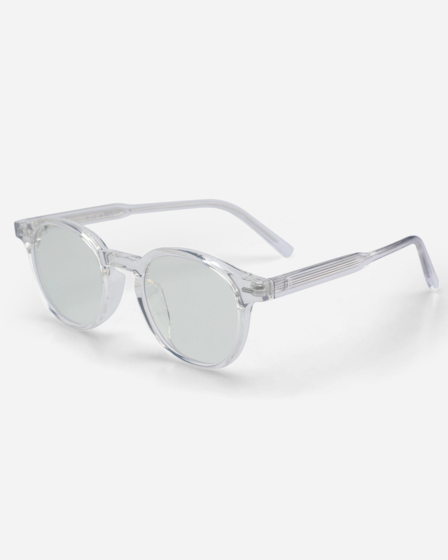 Clear sunglasses with round lenses and transparent frames on a plain background.