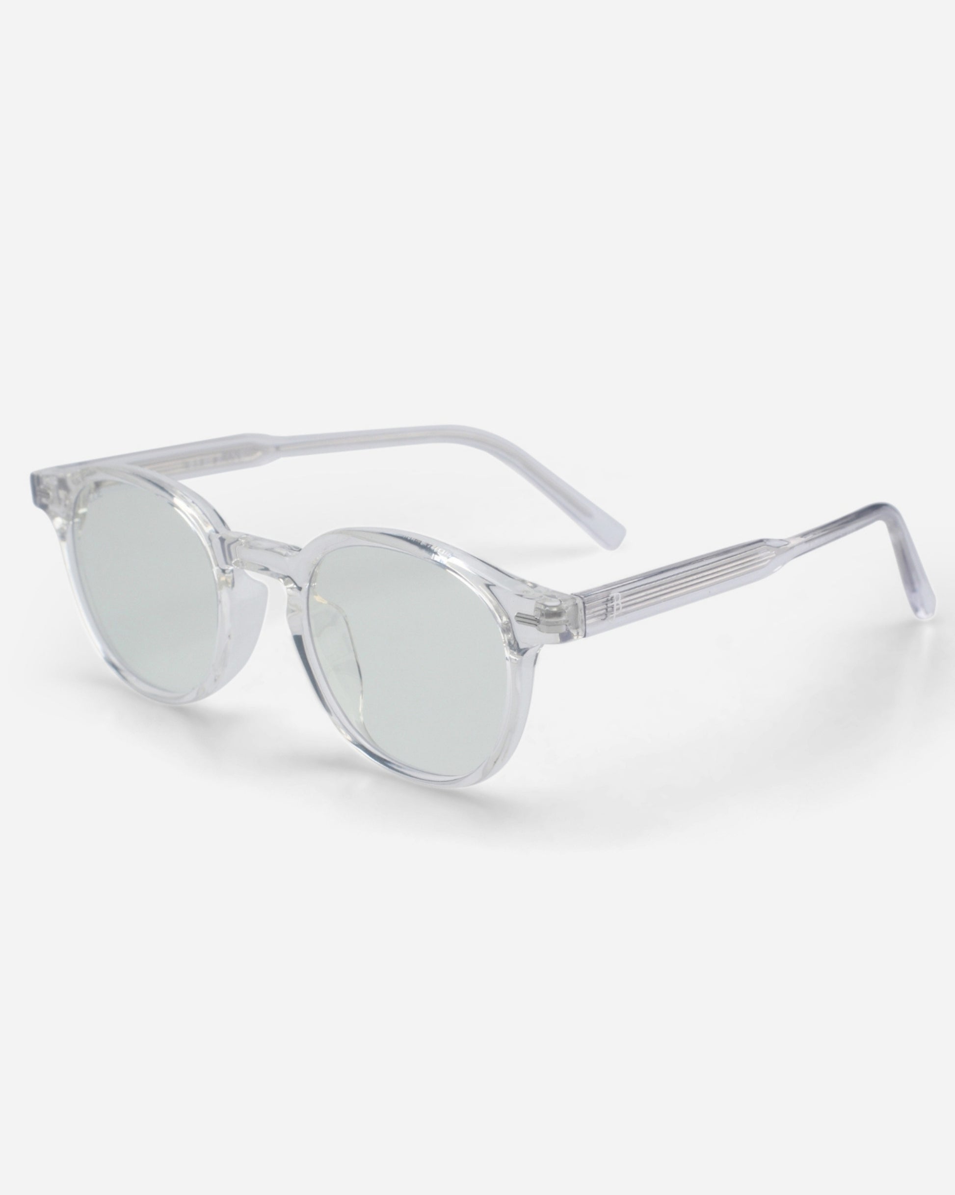 Clear sunglasses with round lenses and transparent frames on a plain background.