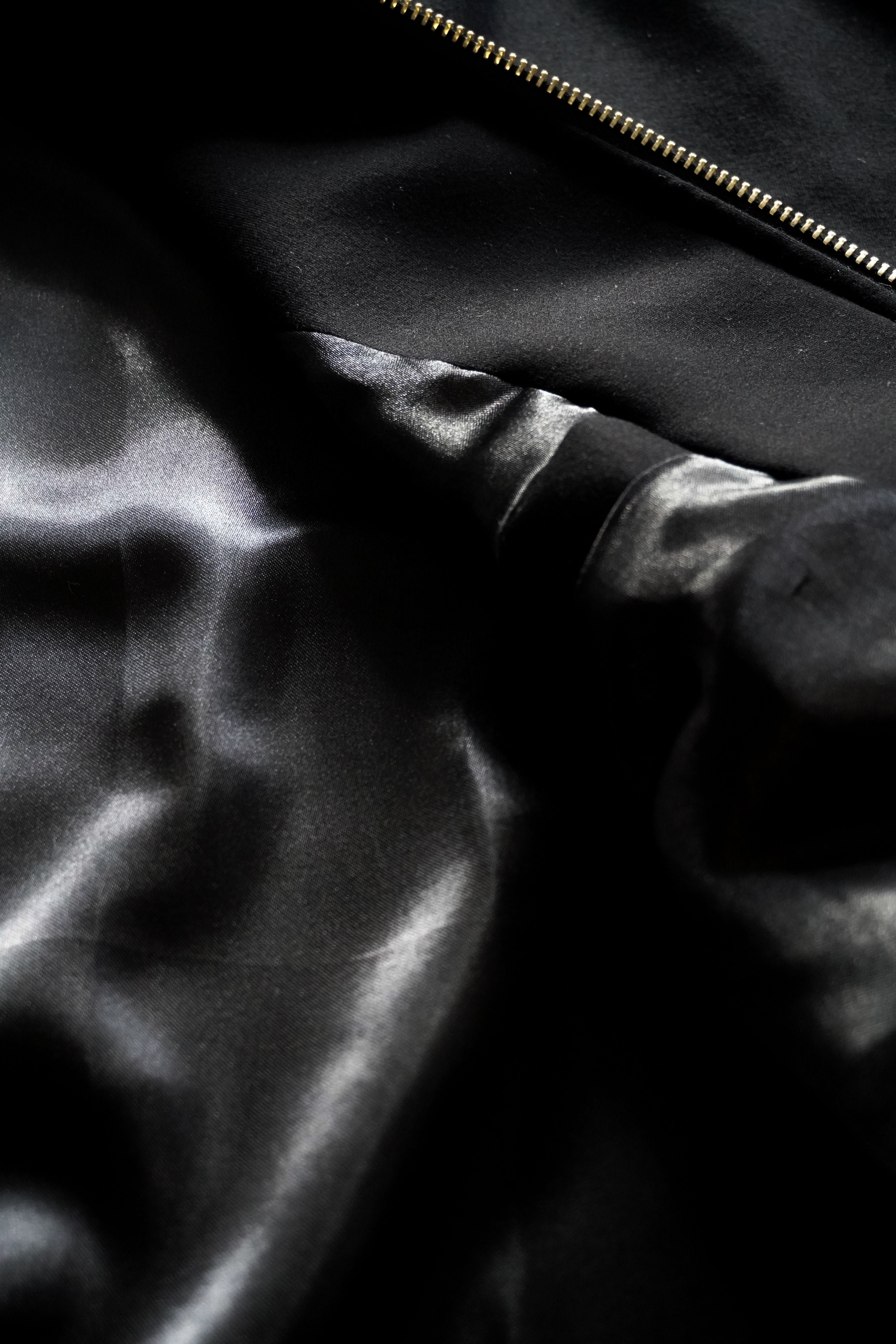 Close-up of a black satin fabric with a zipper