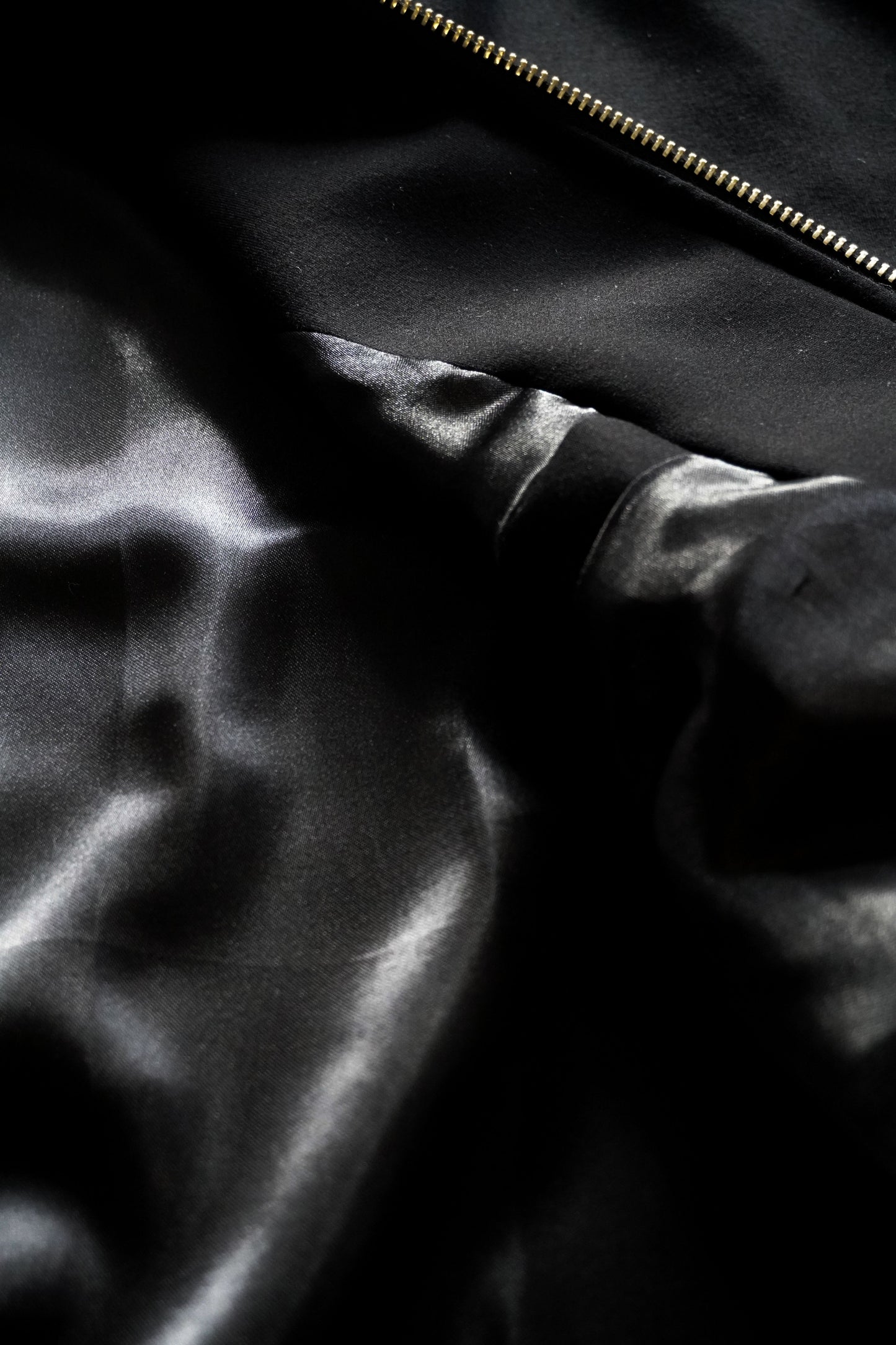 Close-up of a black satin fabric with a zipper