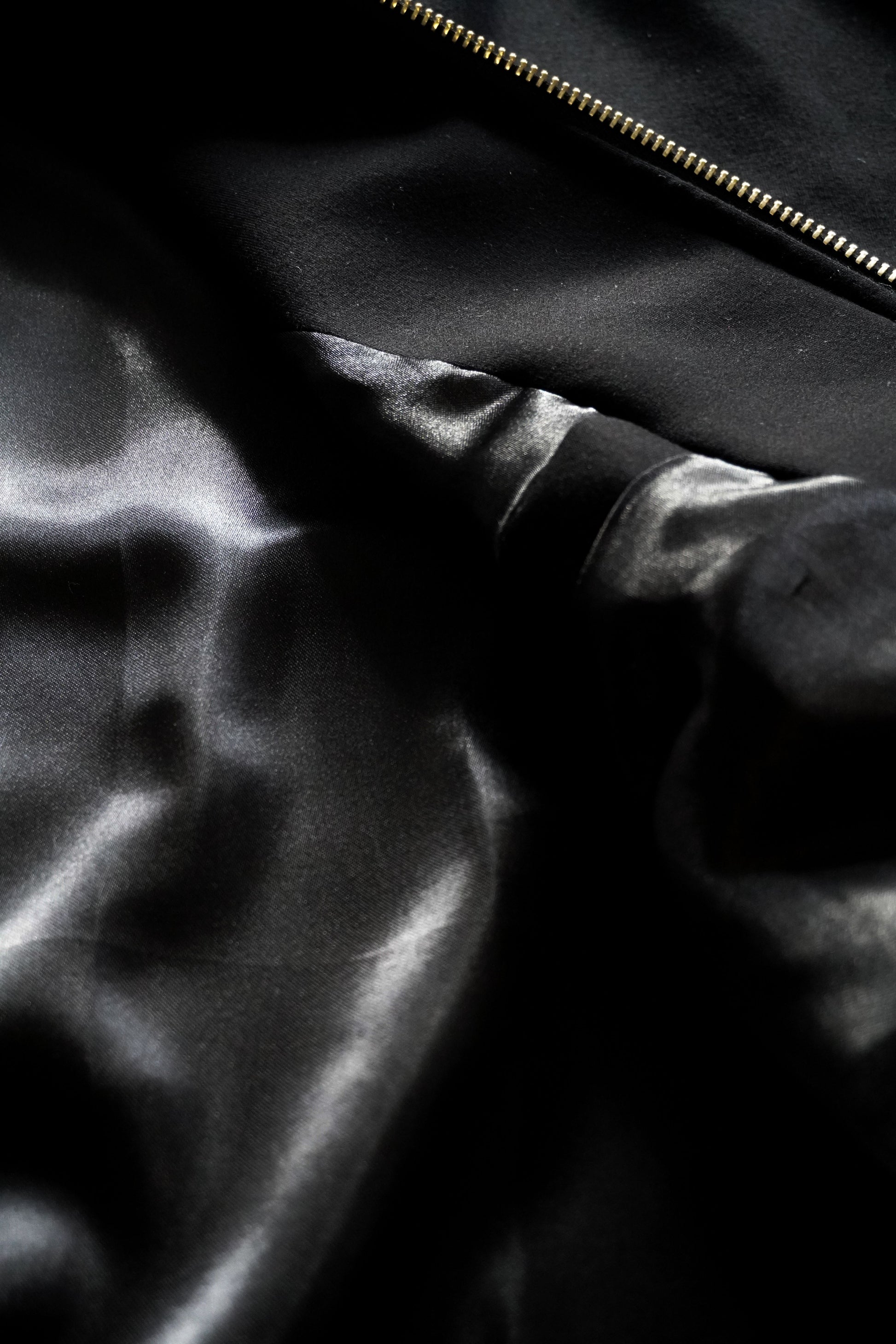 Close-up of a black satin fabric with a zipper