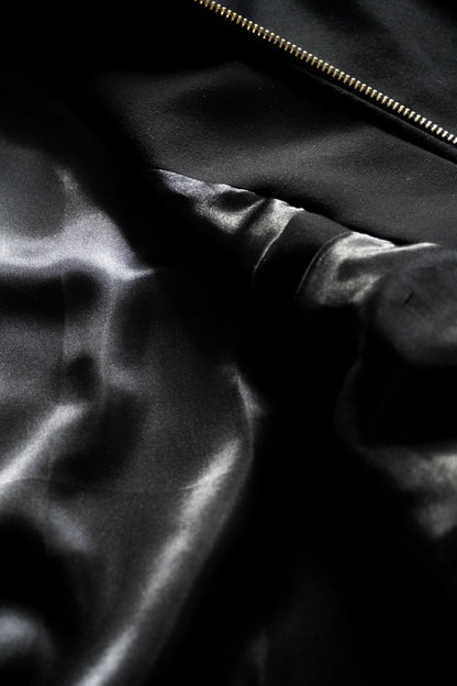 Close-up of a black satin fabric with a zipper