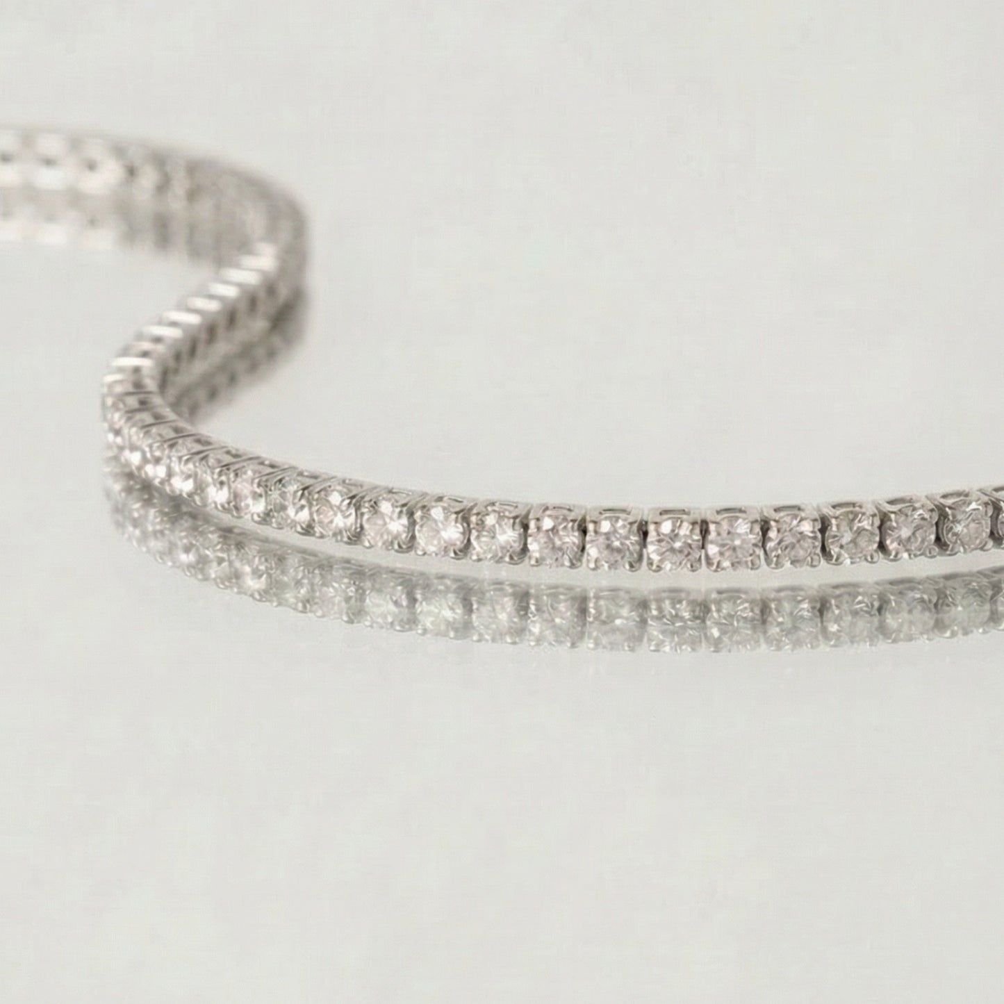 Silver bracelet with clear stones on a light gray background